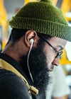 Picture of man listening to podcast with earphones.